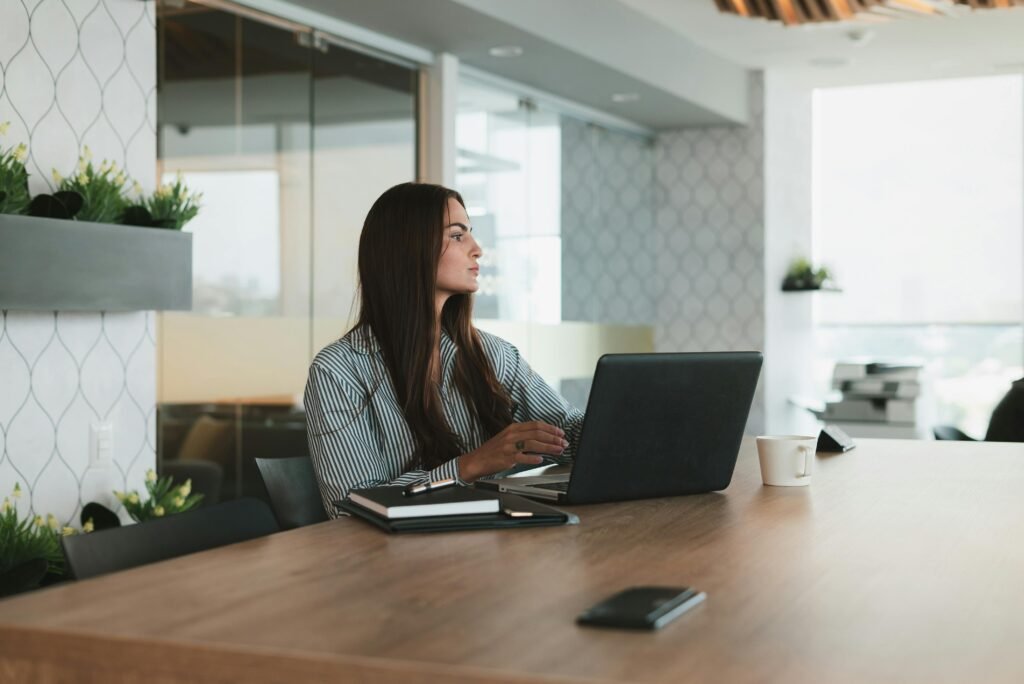 Woman working on a laptop at a desk in a modern office